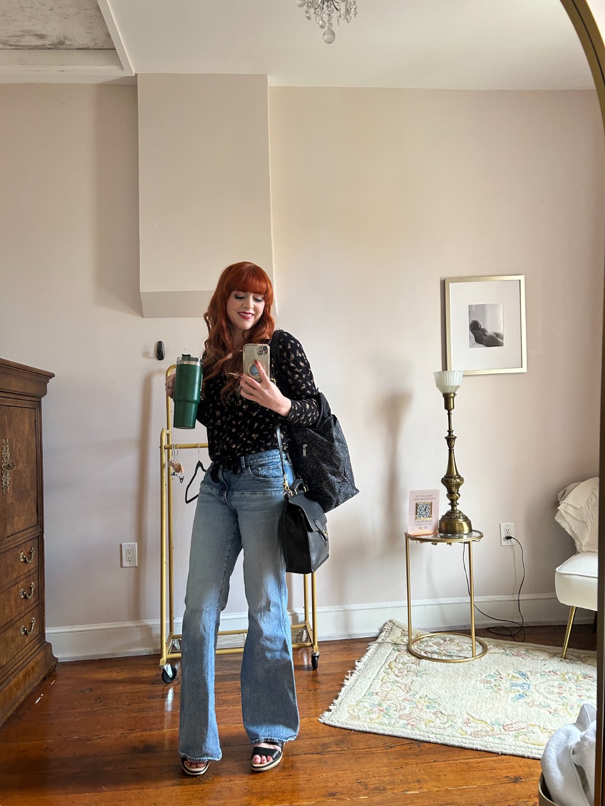 Stephanie taking a mirror selfie holding an iced coffee tumbler